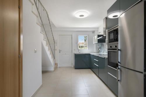 a kitchen with blue cabinets and a refrigerator at Bonita Casa Adosada in Zahara de los Atunes