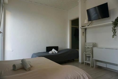 a bedroom with two beds and a flat screen tv at Central View Loft in Lignano Sabbiadoro
