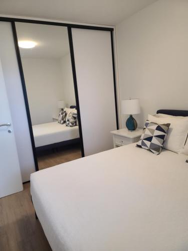 a bedroom with a white bed and a mirror at Apartment Anna in Čapljina