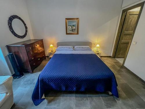 a bedroom with a blue bed and a dresser and a mirror at Casa Vacanze da Anna e Turi in Solità