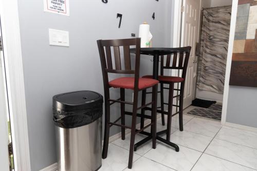 a kitchen with two bar stools and a trash can at Cozy Private Entry Apt with a Full-Size Kitchen in Orlando