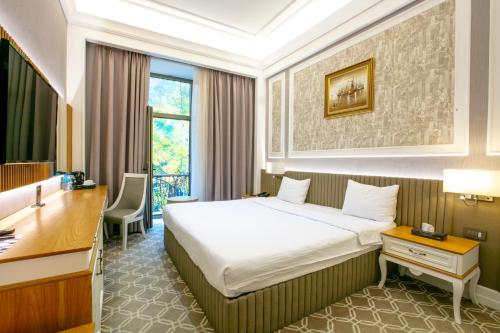 a hotel room with a bed and a desk at Theatrum Hotel Baku in Baku
