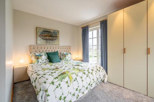 a bedroom with a large bed and a window at Blauw aan zee in De Panne