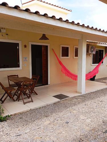 a house with a table and chairs in front of it at Chalés Estrelas Do Mar in Barra Nova