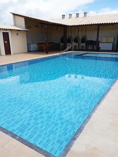 a large swimming pool with blue water at Chalés Estrelas Do Mar in Barra Nova