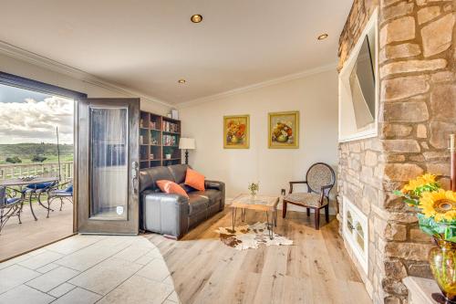 a living room with a couch and a stone fireplace at Near Wineries and Dining Exquisite Menifee Home! in Menifee
