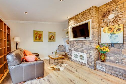 a living room with a couch and a stone fireplace at Near Wineries and Dining Exquisite Menifee Home! in Menifee