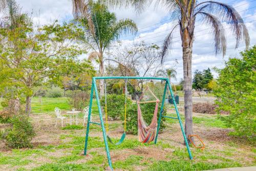 a swing in a park with a palm tree at Near Wineries and Dining Exquisite Menifee Home! in Menifee