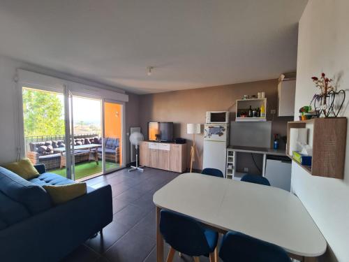 une cuisine et un salon avec une table et un canapé dans l'établissement Studio à Fréjus, à Fréjus