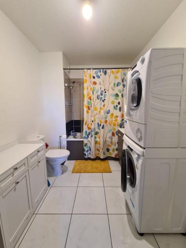 La salle de bains blanche est pourvue d'un lave-linge et d'un sèche-linge. dans l'établissement Studio à Fréjus, à Fréjus