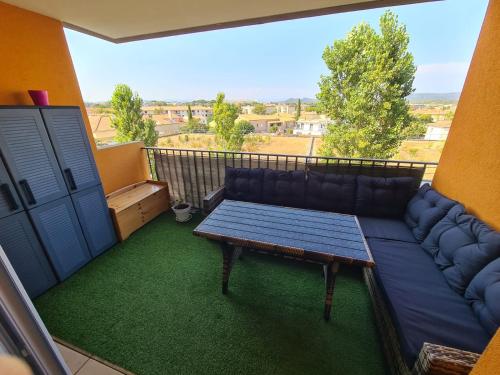 - une terrasse couverte avec un canapé et une table sur un balcon dans l'établissement Studio à Fréjus, à Fréjus