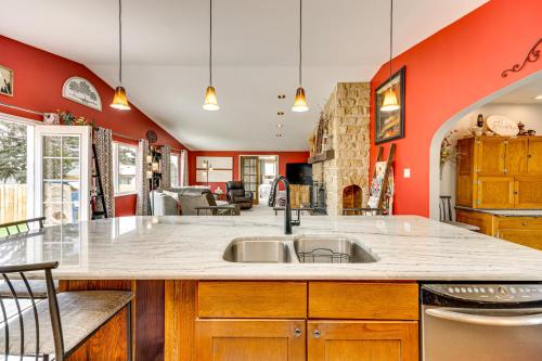 a kitchen with a sink and red walls at 1 Mi to Attractions Getaway with Mtn Views! in Colorado Springs