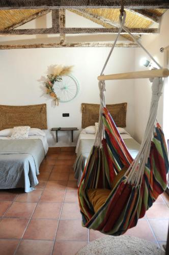 a room with two beds and a hammock at Casa Rural El Gallo in Casas de Haro