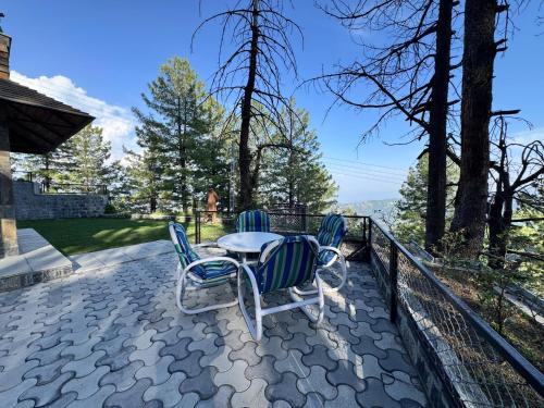 a patio with two chairs and a table on a balcony at Haven Lodge Khaira Gali - Pine Ridge Residences #7 in Khaira Gali