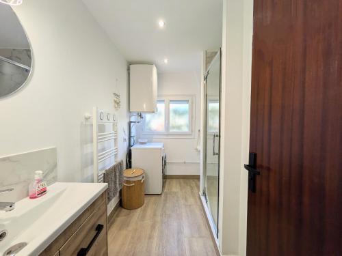 une salle de bain avec un lavabo et un miroir dans l'établissement Les Tulipes - T3 rénové avec parking, terrasse et climatisation, à Canet