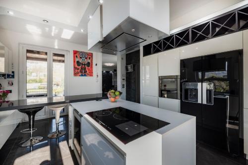 a kitchen with black and white cabinets and a counter at k10 Luxury House, Pool, Jacuzzi, Gym, Private Garden in Lipomo