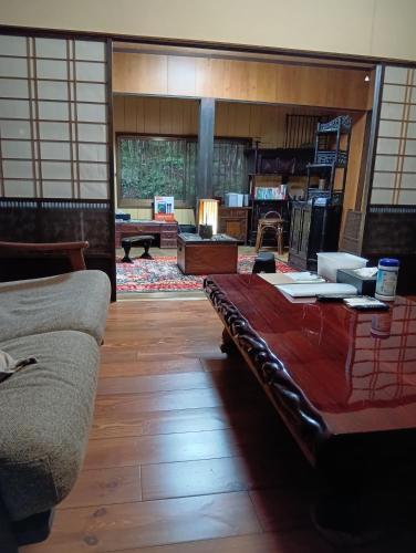 a living room with a couch and a table at 横城ゲストハウス 自然豊かなプライベート空間 古民家一棟貸しの宿 in Kitsuki