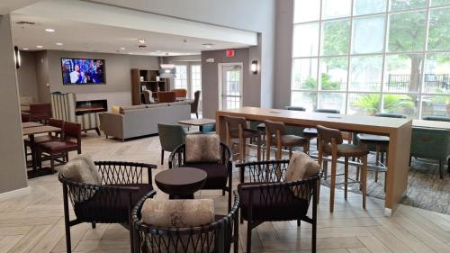 a restaurant with chairs and a table and a bar at Staybridge Suites Austin Airport by IHG in Austin