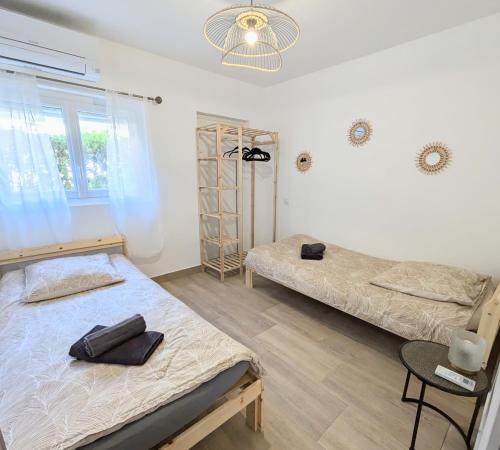 une chambre avec deux lits et une fenêtre dans l'établissement Les Tulipes - T3 rénové avec parking, terrasse et climatisation, à Canet