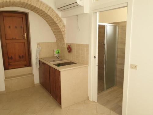 a kitchen with a sink and a shower at Nonna Livia by La Puglia in un trullo in Alberobello