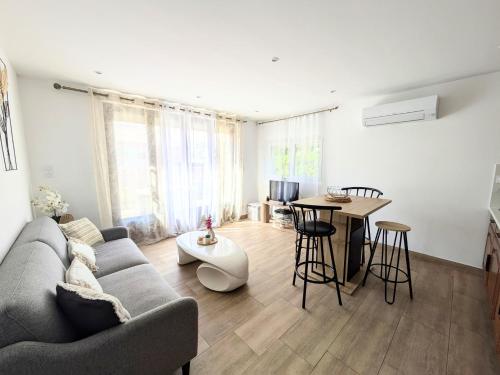 un salon avec un canapé et une table dans l'établissement Les Tulipes - T3 rénové avec parking, terrasse et climatisation, à Canet