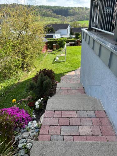 a brick walkway leading to a yard with flowers at Gemütliche Ferienwohnung mit Sonnenterrasse in Schlitz