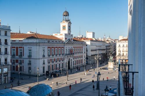 a city street with a clock tower on a building at LUTHIA Puerta del Sol in Madrid