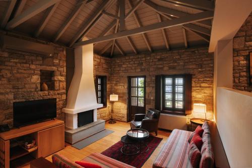 a living room with a couch and a tv at Aristi Mountain Resort in Aristi