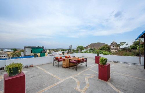 a balcony with a table and chairs on a roof at Braj Villa in Udaipur