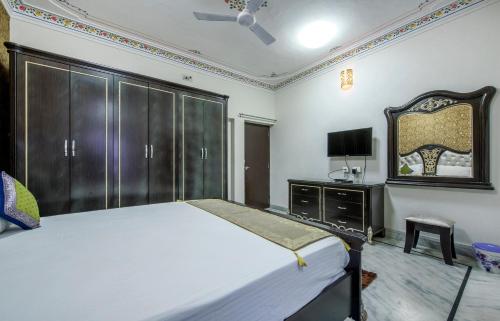 a bedroom with a large bed and a tv at Braj Villa in Udaipur