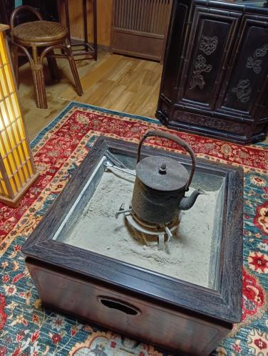 an old tea kettle in a box on a rug at 横城ゲストハウス 自然豊かなプライベート空間 古民家一棟貸しの宿 in Kitsuki