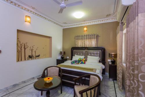 a bedroom with a bed and a table and chairs at Braj Villa in Udaipur