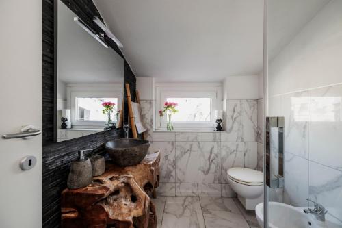 a bathroom with a sink and a toilet at k10 Luxury House, Pool, Jacuzzi, Gym, Private Garden in Lipomo