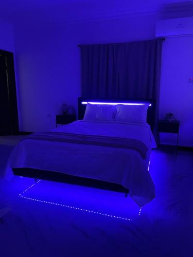 Un dormitorio azul con una cama con una luz azul. en Argyle Escape, en Kingston