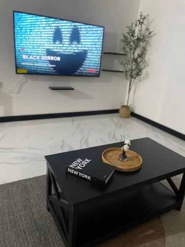Una mesa de café negra en una habitación con un televisor. en Argyle Escape, en Kingston