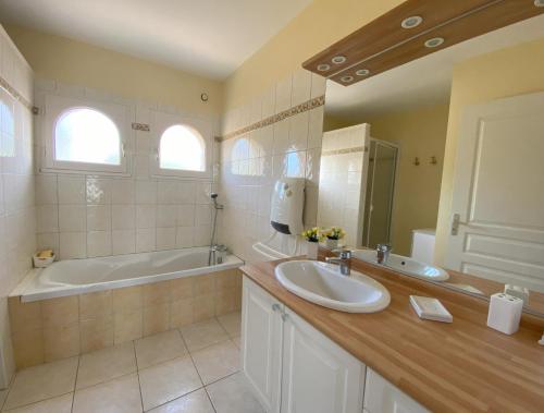 une salle de bain avec un lavabo et une baignoire dans l'établissement Maison à 300m de la mer à l'ILE GRANDE - PLEUMEUR-BODOU - Réf 267, à Pleumeur-Bodou