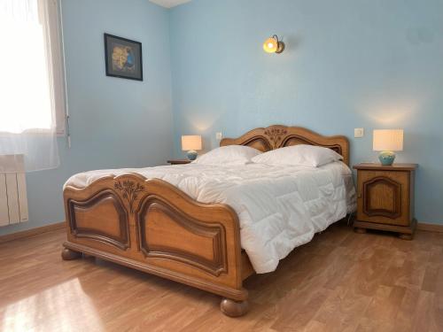 - une chambre avec un grand lit en bois et 2 tables de chevet dans l'établissement Maison à 300m de la mer à l'ILE GRANDE - PLEUMEUR-BODOU - Réf 267, à Pleumeur-Bodou