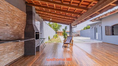 a patio with a wooden floor and a brick wall at Casa Aconchegante em Bertioga a 700m da Praia in Bertioga