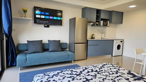 a living room with a blue couch and a kitchen at СС619 Романтика, чудесный вид и домашний уют in Mai Khao Beach
