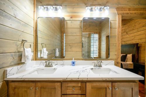 a bathroom with two sinks and a large mirror at Serenity Pines-3bd/2bth, Sleeps 8, Hot tub+Arcades in Stephens Gap