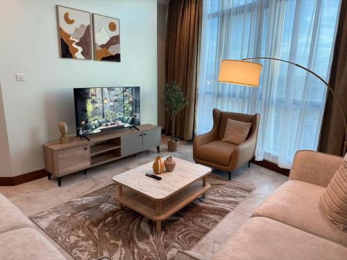 a living room with a couch and a television at Fairview Luxury Apartments in Dar es Salaam