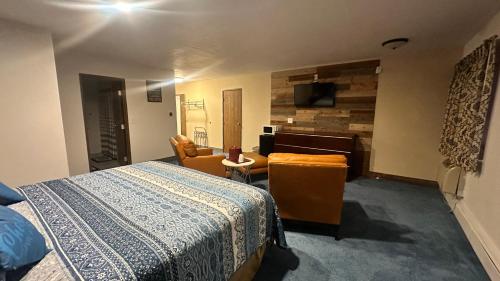 a bedroom with a bed and a room with a desk at Chesaning INN & Suites in Chesaning