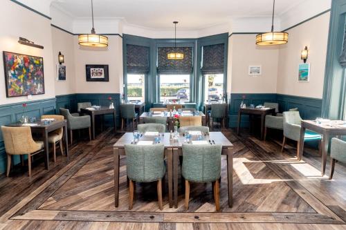 a dining room with tables and chairs at The Lansdowne, Eastbourne in Eastbourne