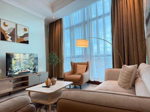 a living room with a couch and a tv and a chair at Fairview Luxury Apartments in Dar es Salaam