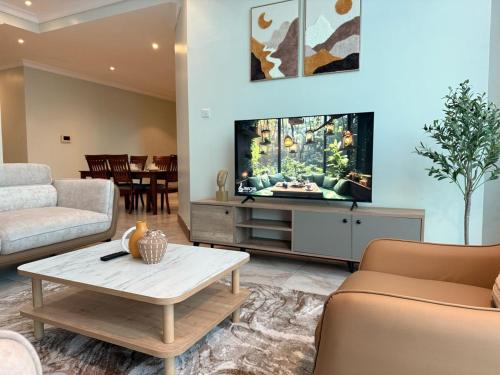 a living room with a tv and a coffee table at Fairview Luxury Apartments in Dar es Salaam
