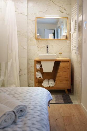 une salle de bain avec un lavabo et un miroir dans l'établissement Bulles de bonheur - hyper centre d'Épernay, à Épernay