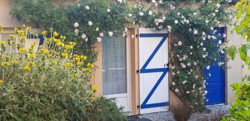 a house with a blue door and flowers at La Tourelle - Bed and Breakfast et gîte in Changé