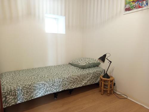 a bedroom with a bed and a lamp on a table at Gîte du Tourney in Faleyras