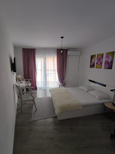 a bedroom with a bed and a table and a window at Casa Dobro Dubova in Dubova