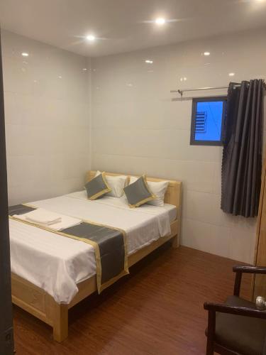 a bedroom with a bed with white sheets and a window at Hai Dang Hotel in Can Tho
